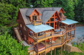 Riverview Lodge | Cabin Rentals of Georgia | aerial view of three story lodge showcasing spacious covered decks with dining tables, conversational seating, and rockers