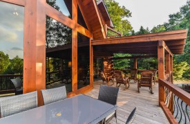 Riverview Lodge | Cabin Rentals of Georgia | Spacious outdoor living on covered and uncovered porches with rockers and dining table and chairs for 6