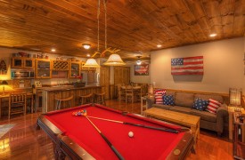 Aska Escape Lodge | Blue Ridge Cabins | Cabin Rentals of Georgia | Terrace Level Game and Living Area with red felt-covered pool table, kitchen, living area with American flag decor