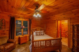 Riverview Lodge | Cabin Rentals of Georgia | Terrace Level Queen Suite with stained concrete floors, private ensuite bath, brown leather chair