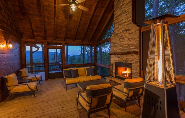 Cozy Conversational Living w/ Wood-burning Fireplace Above the Timberline | Cabin Rentals of Georgia | Outdoor screens-in porch with comfortable conversational seating in front of a crackling fire in fireplace and North GA Mountain views